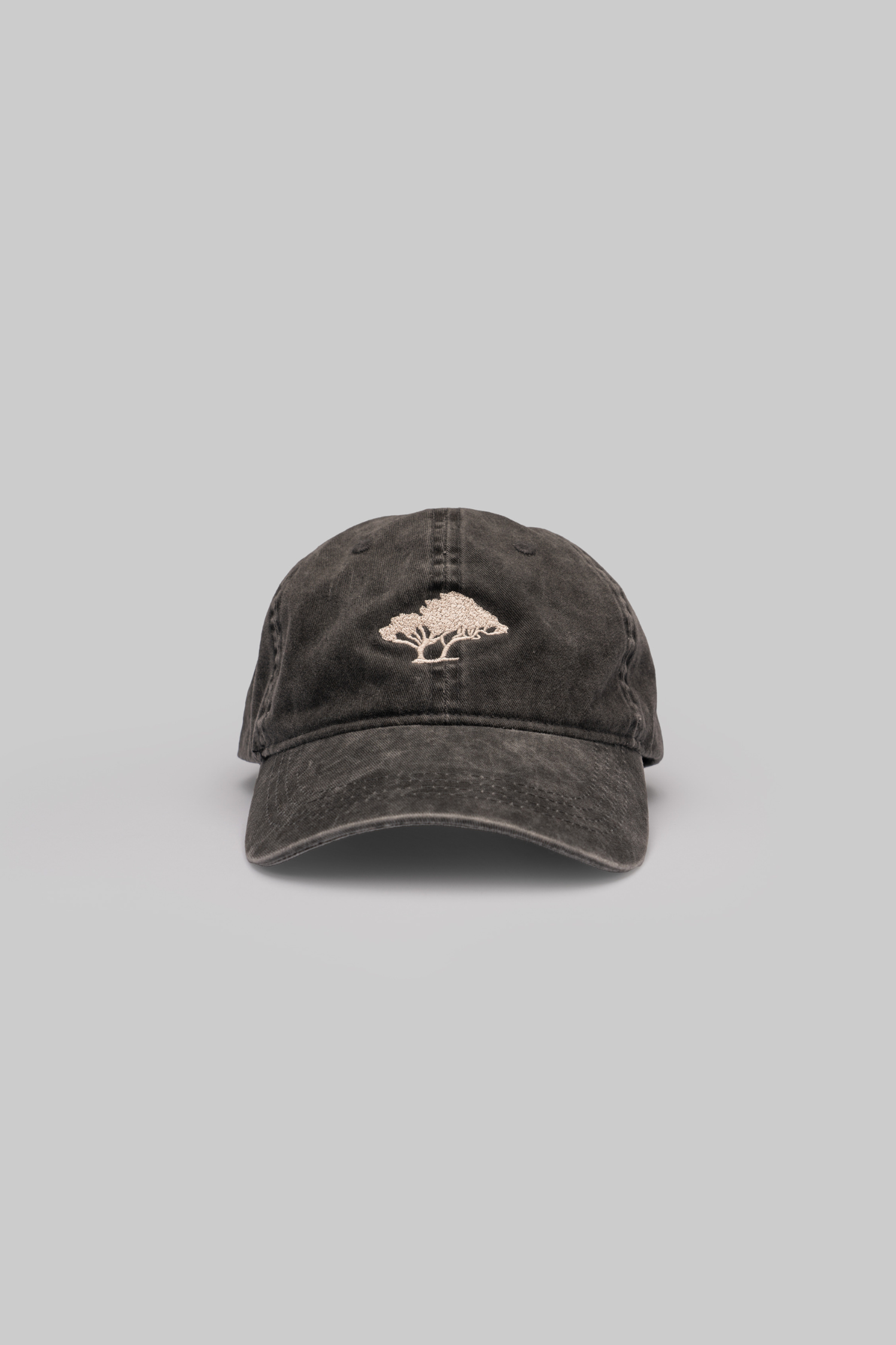 Black cap with a tree logo on a gray background