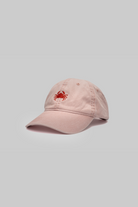 Pink cap with a red crab logo on a light gray background